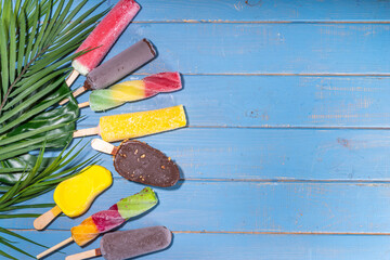 Various ice cream popsicle on high-colored yellow background, summer sweets, dessert, vacation and holiday background, Set of assorted flavors popsicle lollipops - chocolate, vanilla, fruit, rainbow 