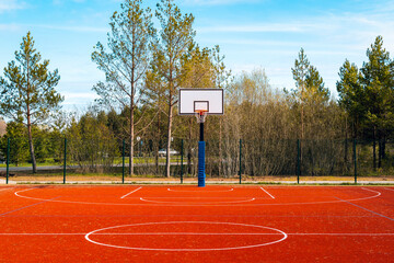 Empty basketball court on sunny day