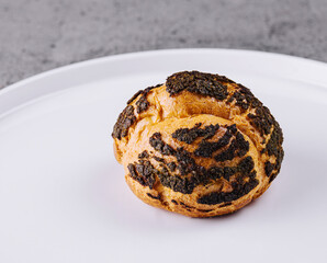 A profiterole, french choux pastry covered chocolate chips