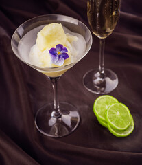 Peach and melon sorbet in bowl with a glass of champagne