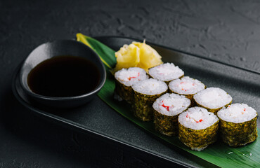 Sushi roll set in a plate on black plate