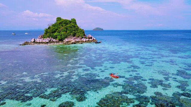 couple with a kayak on a small Island in front of the Island of Ko Lipe Thailand, Kla Island