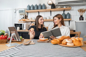 girl chef helping each other to cook healthy food of salad from tasty organic vegetable by learning recipe instruction from online diet course on tablet