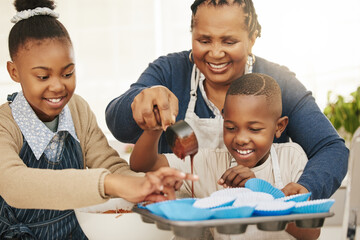 Well make extra to take home. Shot of a grandmother baking with her two grandkids at home.