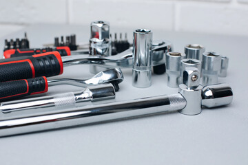 A set of working tools, a hammer, a screwdriver, sockets for an answer on a gray concrete background. Front view