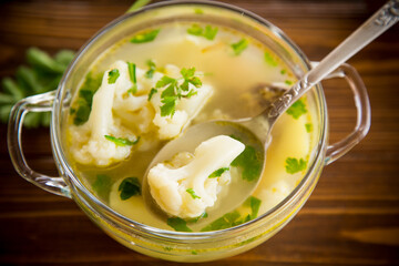 cooked chicken soup with cauliflower and vegetables in a bowl