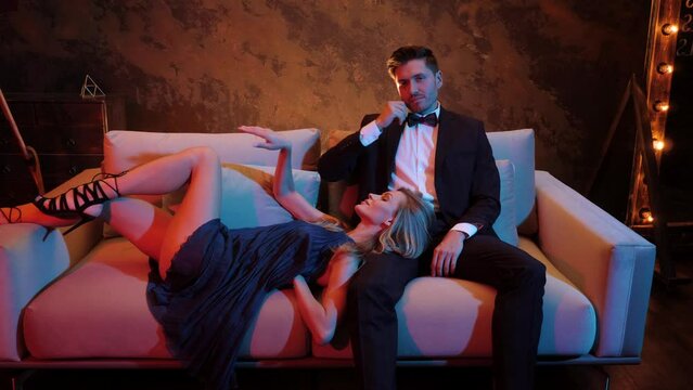 Seduce, temptation, passion, flirting. Couple in love. Brutal, Bearded Attractive young cool guy and Sexy blonde girl in the Neon light.