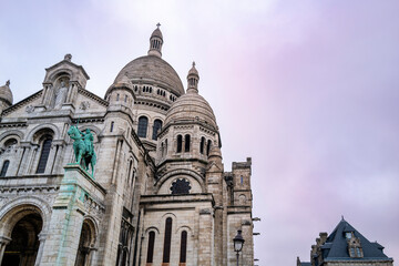 The Sacre Coeur Basilica on the hill of Montmartre in France with the pink and blue sky in the backgrounds