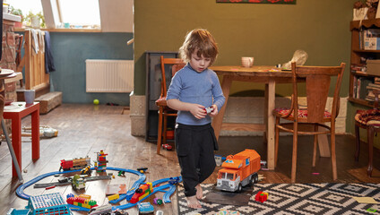 A little boy is playing with toys in the room