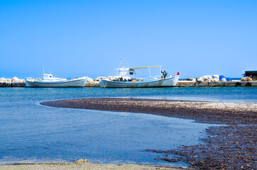 Small white fishing boats in the small harbor of Skyros island