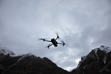 Obraz na płótnie Canvas Flying drone in high altitude mountains