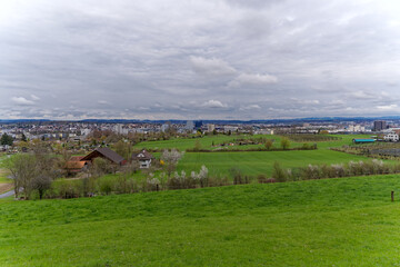 Beautiful agriculture landscape with trees in bloom at City of Zürich district Schwamendingen on a cloudy spring day. Photo taken April 7th, 2023, Zurich, Switzerland.