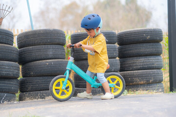  Kid Asian Baby Boy wearing safety bike helmet playing Scooter or Balance bike in the playground