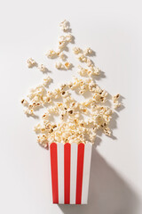 Classic striped bucket with delicious popcorn on white background