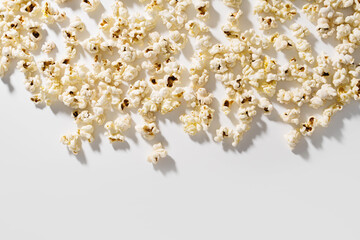 Scattered popcorn on white background with hard lighting