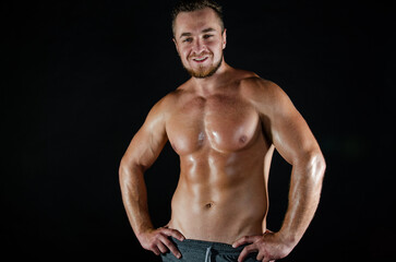 Fototapeta na wymiar Young handsome trainer posing in the studio. A man with a beautiful athletic body.