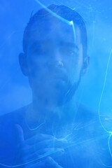 Creative portrait of young handsome man with mist and blue light