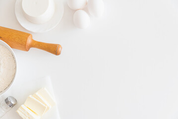 Frame of cooking cake ingredients. Flour, eggs and butter on white table. Copy space. Top view