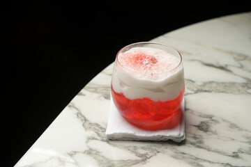 Glass of red cocktail with coconut flakes