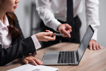Young confident business people sitting at the office table working analyze on laptop computer with partner. Business concept