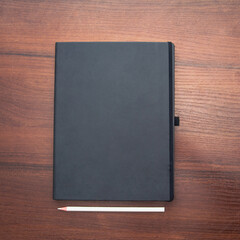 Fototapeta premium Notebook and pencil on a beautiful background in a photo studio