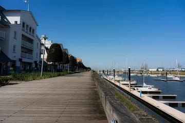 Foto op Aluminium Walking route in Nieuwpoort along 1 of the largest marinas in Europe with a view of the North Sea and the harbour.  There is a large wide renewed path for both cyclists and walkers. © robin