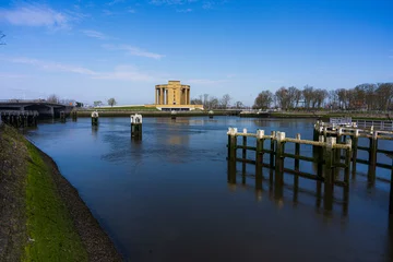 Deurstickers Overview at the Westfront located at city Nieuwpoort at the belgium coast.  River de ijzer with the Koning Albert I monument and a blue sky.  Belgium coast toerism picture.  With the water dam. © robin