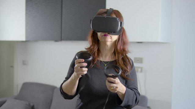 donna che usa visore di realt&agrave; virtuale in salotto