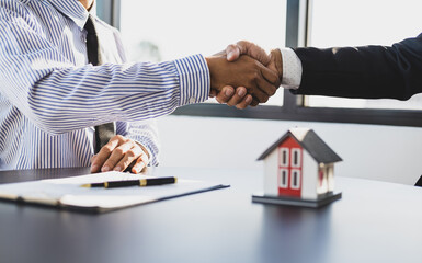 Real estate agents businessmen shake hands after the signing of the contract agreement is complete.