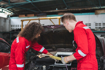 Young Caucasian car mechanic with a checklist, Mechanics in uniform are working in auto service, Technician checking modern car at garage, Car repair and maintenance concepts