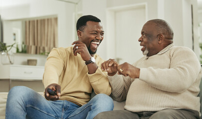 A happy family is but an earlier heaven. Shot of a father and son laughing in the lounge.