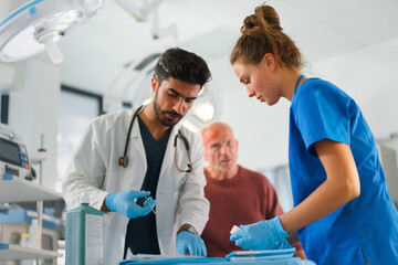 Obraz premium Young doctor and nurse treating injury of senior man.