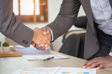 Satisfied black client shaking hands, thanking the manager for good financial deal African American businessmen shaking hands after successful business negotiations. Hiring. Buying services.