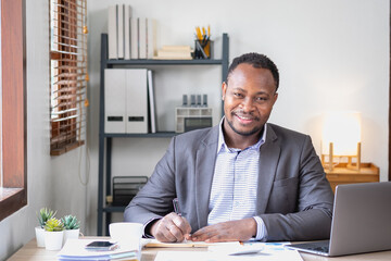 An African American businessman in a black suit smiling and showing joy at the company's annual...