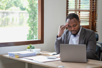 Concept Burnout Syndrome. African American businessman feels uncomfortable working, which is caused...