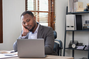 Concept Burnout Syndrome. African American businessman feels uncomfortable working, which is caused...