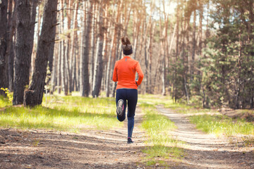 young girl on a morning run in a sunny pine forest