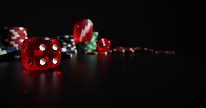 Closeup of falling red dice and casino chips on black background. Gambling and entertainment concept poker and gambling