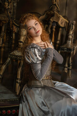 Close-up portrait of a red-haired girl in a gray medieval dress on a wooden carousel with horses