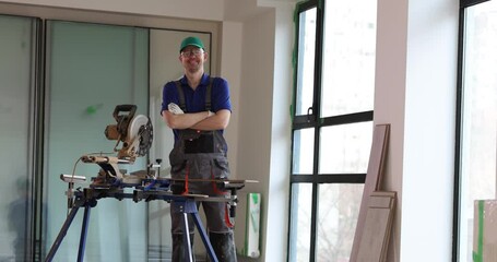 Smiling male builder carpenter and sawmill. Repair and flooring services
