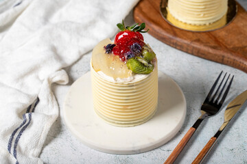 Cream cake surrounded by chocolate. Chocolate and fruit cake on gray background. Studio shoot. Bakery products