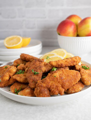 Little chicken schnitzels coated with bread crumbs on a platter. Kid friendly food