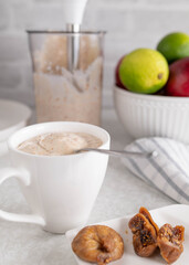 Yogurt with dried figs in a cup on kitchen counter