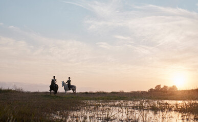 Feel the air, smell the foliage and explore natures beauty. Shot of two young women out horseback riding together.
