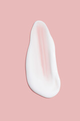 A dab of cosmetic cream. Light, smooth surface. Texture of spreadable cream. Liquid cream smear. On a pink background.