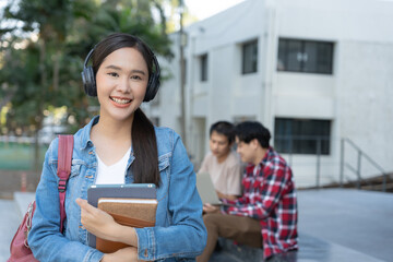 Beautiful student asian woman with backpack and books outdoor. Smile girl happy carrying a lot of book in college campus. Portrait female on international Asia University. Education, study, school