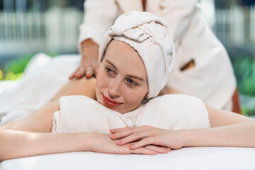 Obraz na płótnie Canvas Masseuse doing back massage to relieve pain of beautiful caucasian woman in spa and wellness