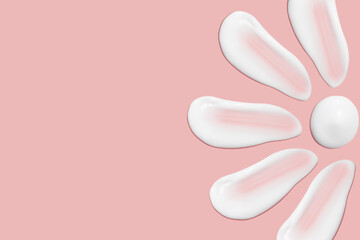 Lots of smears of cosmetic cream. Light, smooth surface. Texture of spreadable cream. Liquid creamy strokes. On a pink background. Cosmetic background, banner.