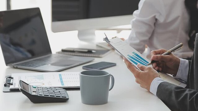 Financial analysts analyze business financial reports on a digital tablet planning investment project during a discussion at a meeting of corporate showing the results of their successful teamwork.