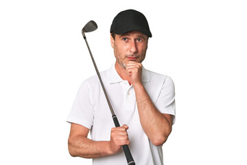 Middle aged golfer man looking sideways with doubtful and skeptical expression.